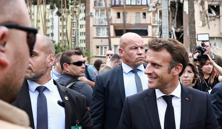 French President Emmanuel Macron smiles during a visit alongside Italian Prime Minister Mario Draghi, German Chancellor Olaf Scholz, and Romanian President Klaus Iohannis to Irpin, as Russia's attack on Ukraine continues, near Kyiv, Ukraine June 16, 2022 | Reuters