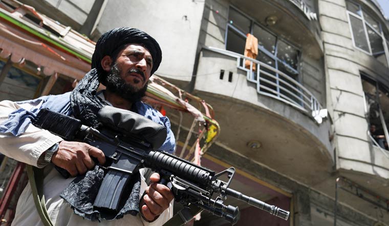 A Taliban fighter stands guard at the site where an explosive-laden vehicle detonated amidst an attack on a Sikh Temple in Kabul, Afghanistan, June 18, 2022 | Reuters