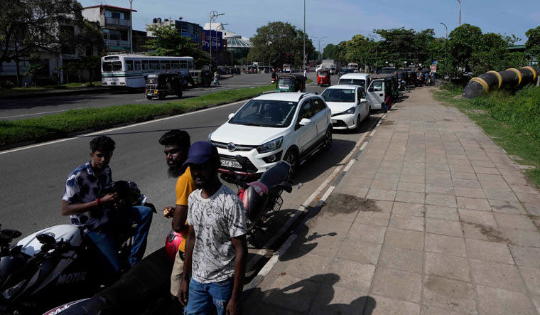 Motorists wait in a queue expecting to buy fuel in Colombo | AP