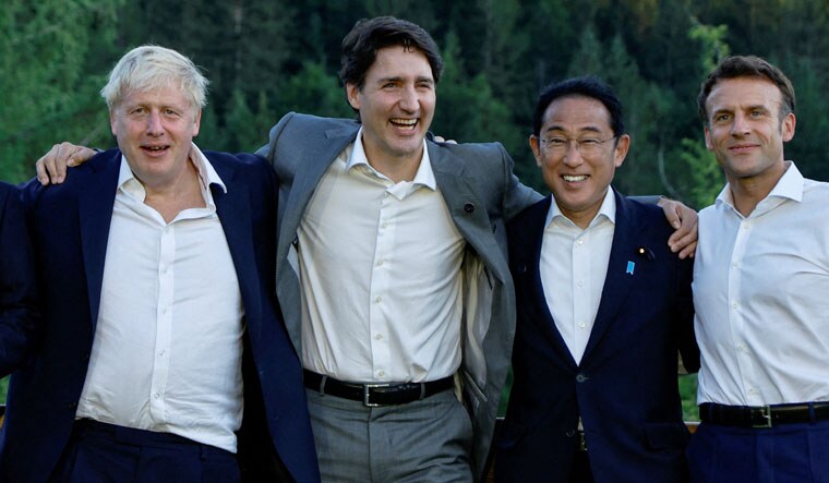 British Prime Minister Boris Johnson, Canadian Prime Minister Justin Trudeau, Japanese Prime Minister Fumio Kishida and French President Emmanuel Macron pose for a photograph next to a bench where Germany's then-Chancellor Angela Merkel and U.S. then-President Barack Obama were photographed during a G7 summit in 2015, during the first day of the G7 leaders' summit at Bavaria's Schloss Elmau castle, near Garmisch-Partenkirchen, Germany, June 26, 2022. REUTERS/Jonathan Ernst