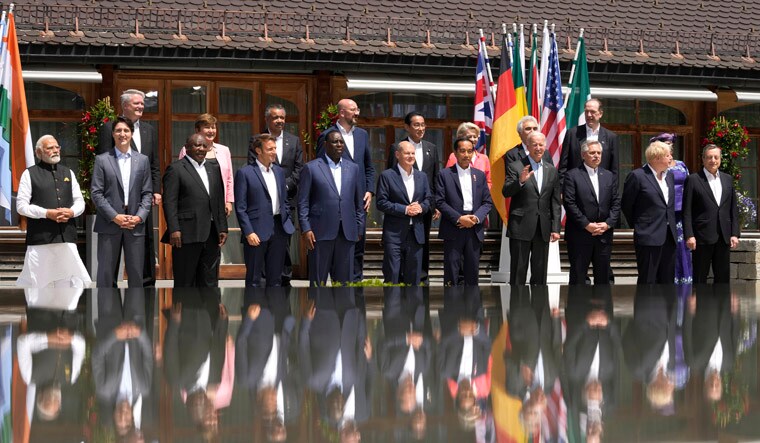 U.S. President Joe Biden, front fourth right, waves as he poses with G7 leaders and Outreach guests for an official group photo at Castle Elmau in Kruen, near Garmisch-Partenkirchen, Germany, on Monday, June 27, 2022. The Group of Seven leading economic powers are meeting in Germany for their annual gathering Sunday through Tuesday. (AP Photo/Markus Schreiber)