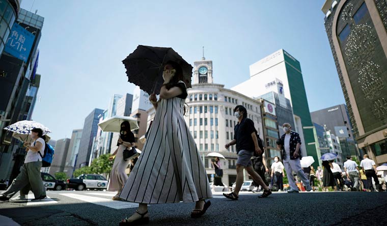 People walk over a pedestrian crossing under an intense sun Tuesday, June 28, 2022 | AP