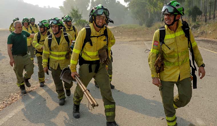 Firefigters walk in the area of a wildfire in Pujerra, Malaga, on Thursday, June 9, 2022 | AP