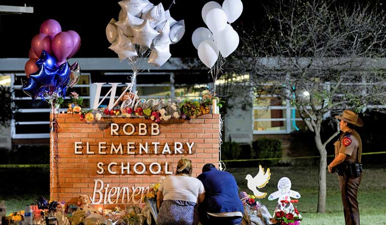 People pay their respects at a makeshift memorial outside Robb Elementary School, the site of a mass shooting, in Uvalde, Texas, US, May 25, 2022 | Reuters