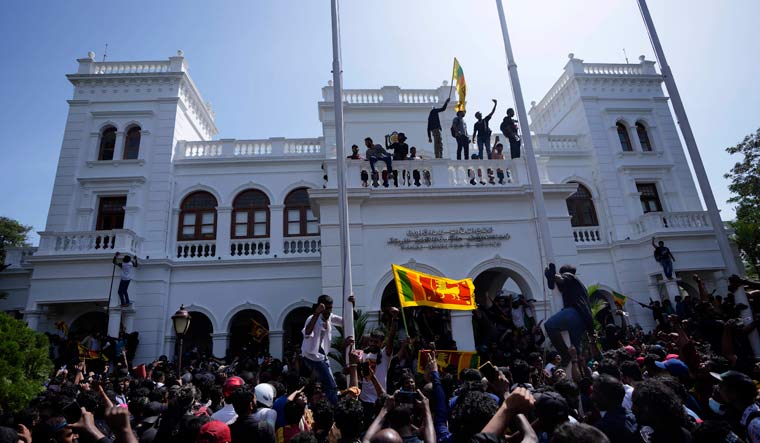 Protesters stand on top of the building of Sri Lankan Prime Minister Ranil Wickremesinghe's office | AP