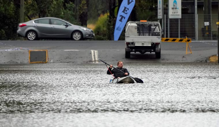 A man paddles his kayak through a flooded street at Windsor on the outskirts of Sydney, Australia, Tuesday, July 5, 2022 | AP