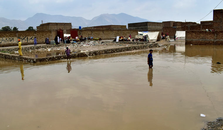 Boys wade through a flooded area on the outskirts of Quetta, Pakistan, Tuesday, July 5, 2022 | AP