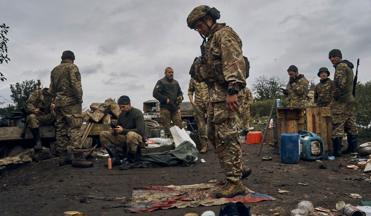 A Ukrainian soldier stands on the Russian flag in Izium, Kharkiv region, Ukraine, Tuesday, Sept. 13, 2022. Ukrainian troops piled pressure on retreating Russian forces Tuesday, pressing deeper into occupied territory and sending more Kremlin troops fleeing ahead of the counteroffensive that has inflicted a stunning blow on Moscow's military prestige. (AP Photo/Kostiantyn Liberov)