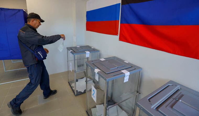 A voter walks to cast his ballot at a polling station on the second day of a referendum on the joining of the self-proclaimed Donetsk People's Republic (DPR) to Russia, in Mariupol, Ukraine September 24, 2022. REUTERS/Alexander Ermochenko