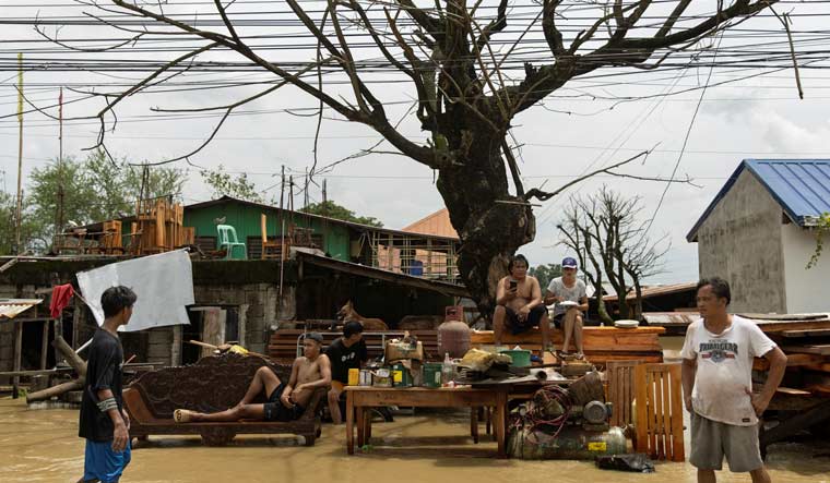 Residents who evacuated from their flooded homes sit on a roadside after Super Typhoon Noru, in San Ildefonso, Bulacan province, Philippines, September 26, 2022 | Reuters