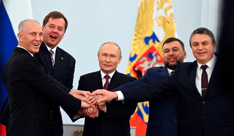 From left, Moscow-appointed head of Kherson Region Vladimir Saldo, Moscow-appointed head of Zaporizhzhia region Yevgeny Balitsky, Russian President Vladimir Putin, center, Denis Pushilin, leader of self-proclaimed of the Donetsk People's Republic and Leonid Pasechnik, leader of self-proclaimed Luhansk People's Republic pose for a photo during a ceremony to sign the treaties for four regions of Ukraine to join Russia, at the Kremlin in Moscow, Friday, Sept. 30, 2022. The signing of the treaties making the four regions part of Russia follows the completion of the Kremlin-orchestrated "referendums." (Grigory Sysoyev, Sputnik, Kremlin Pool Photo via AP)