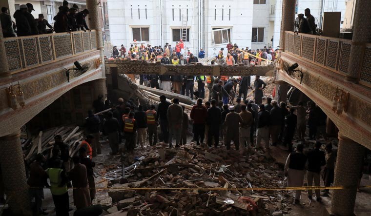People and rescue workers gather to look for survivors under a collapsed roof, after a suicide blast in a mosque in Peshawar, Pakistan January 30, 2023. REUTERS/Fayaz Aziz