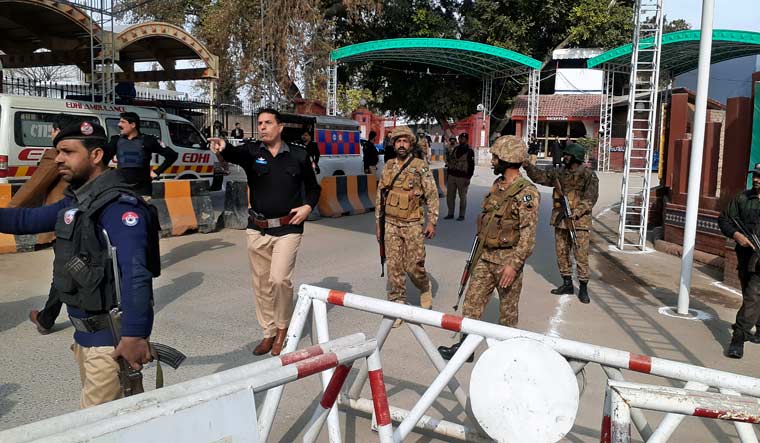 Army soldiers and police officers clear the way for ambulances rushing toward a bomb explosion site, at the main entry gate of police offices, in Peshawar, Pakistan, Monday, Jan. 30, 2023 | AP
