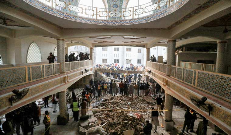 People and rescue workers gather to look for survivors under a collapsed roof, after a suicide blast in a mosque in Peshawar, Pakistan January 30, 2023