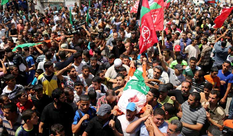 Palestinians march during the funeral of the wife of Hamas's military leader, Mohammed Deif and his infant son Ali who were killed in Israeli air strikes, in the northern Gaza Strip in 2014 | Reuters 

