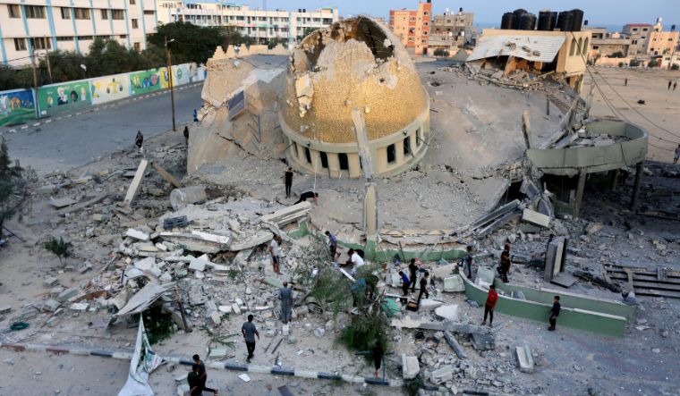 People stand outside a mosque destroyed in an Israeli air strike in Khan Younis, Gaza Strip on October 8, 2023 | AP