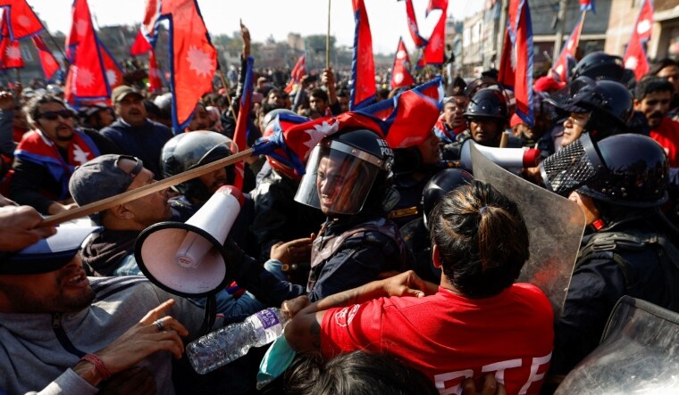 A riot police personal gets a hit on his helmet during the clash with Pro-monarchist protesters in Nepal | Reuters