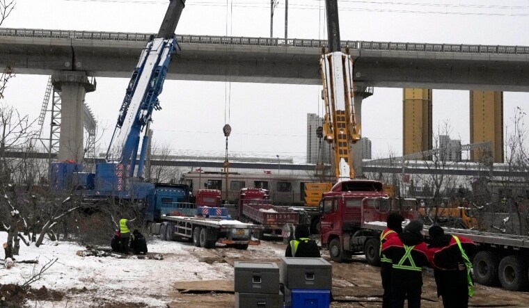 Police officers watch over near the site of train collision on the western district in Beijing | AP