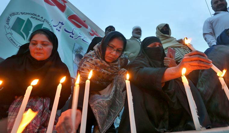 Women light candles during a prayer ceremony for victims of Monday's suicide bombing inside a mosque, in Peshawar, Pakistan, Wednesday, Feb. 1, 2023 | AP