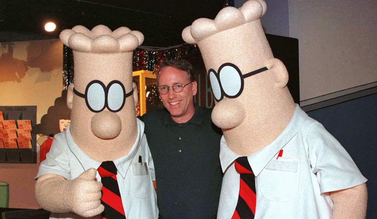 Scott Adams, the creator of "Dilbert", the cartoon character that lampoons the absurdities of corporate life, poses with two "Dilbert" characters at a party January 8, 1999 in Pasadena, Calif | Reuters