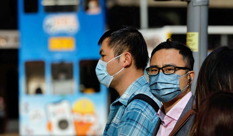 People wear face masks on the street, a day before government scraps the mask rule in Hong Kong, China February 28, 2023 | Reuters