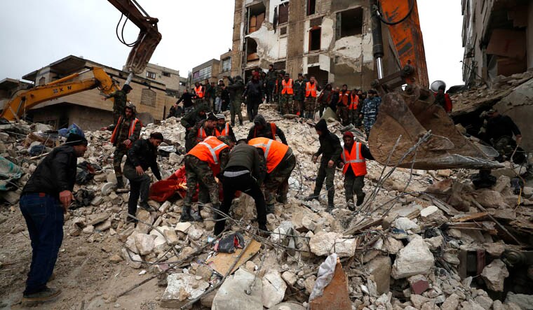 Civil defense workers and security forces search through the wreckage of collapsed buildings in Hama, Syria, Monday, Feb. 6, 2023. A powerful earthquake has caused significant damage in southeast Turkey and Syria and many casualties are feared. Damage was reported across several Turkish provinces, and rescue teams were being sent from around the country. (AP Photo/Omar Sanadik)
