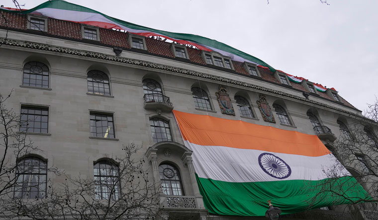 People show an Indian flag from the roof of the Indian High Commission as protesters of the Khalistan movement demonstrate on the streets in London | AP