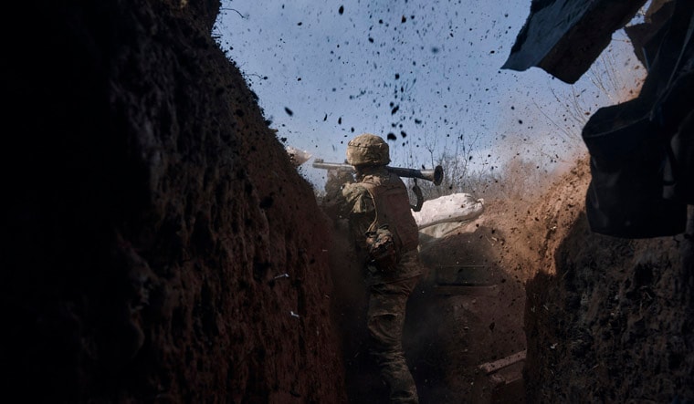 A Ukrainian soldier of the 28th brigade fires a grenade launcher on the frontline during a battle with Russian troops near Bakhmut, Donetsk region, Ukraine, Friday, March 24, 2023. (AP Photo/Libkos)