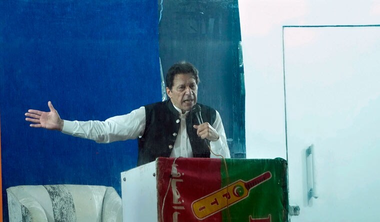 Protected by a bulletproof barrier, former Prime Minister Imran Khan speaks during a rally in Lahore, Pakistan, Sunday, March 26, 2023 | AP