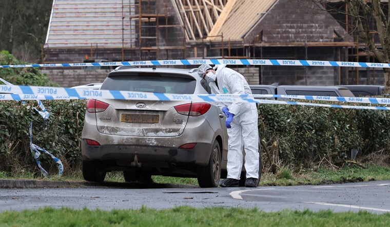 FILE PHOTO: A forensic officer from Police Service of Northern Ireland (PSNI) works at the scene of the Youth Sport Omagh sports complex on Killyclogher Road area, where off-duty PSNI Detective Chief Inspector John Caldwell was shot, in Omagh, Northern Ireland February 23, 2023. REUTERS/Lorraine O'Sullivan/File Photo
