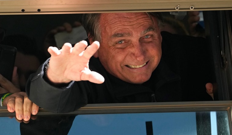 Jair Bolsonaro waves to supporters at the Liberal Party's headquarters in Brasilia, Brazil | AP
