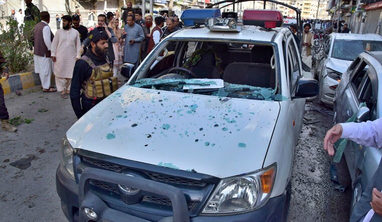 Police officers examine a damaged police vehicle at the site of bomb blast, in Quetta, Pakistan, Monday, April 10, 2023. A roadside bomb targeting a police vehicle in volatile southwestern Pakistan on Monday killed few people and wounded more than dozen others, mostly civilian pedestrians, a government spokesperson said. (AP Photo/Arshad Butt)
