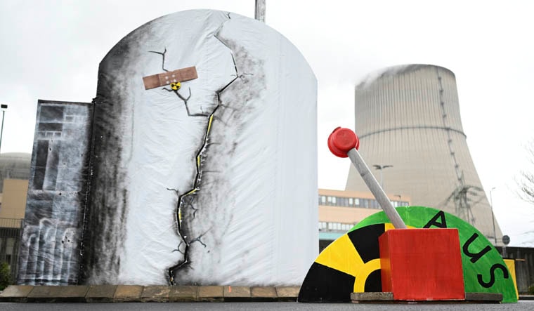 A mock lever to shut down the Emsland nuclear power plant is pictured in front of the power plant in , Lingen, Germany, Saturday, April 15, 2023. Germany is shutting down the last three nuclear power plants today as a part of an energy transition agreed by successive governments. Word reads 'off.' (Lars Klemmer/dpa via AP)