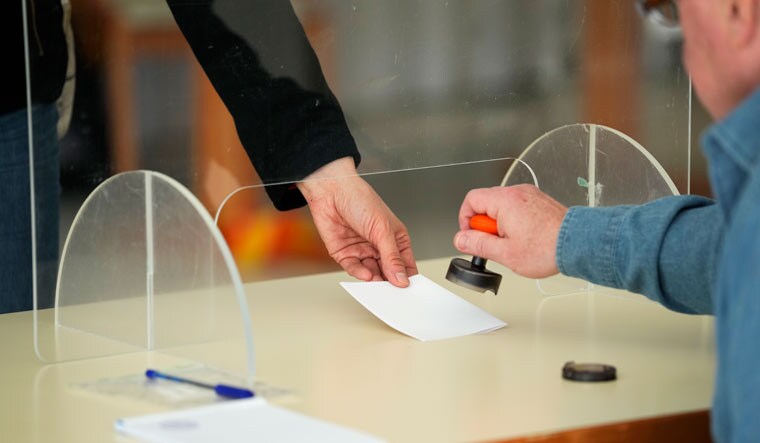 A voter receives a ballot at a polling station during parliamentary election in Turku, Finland, Sunday, April 2, 2023 | AP