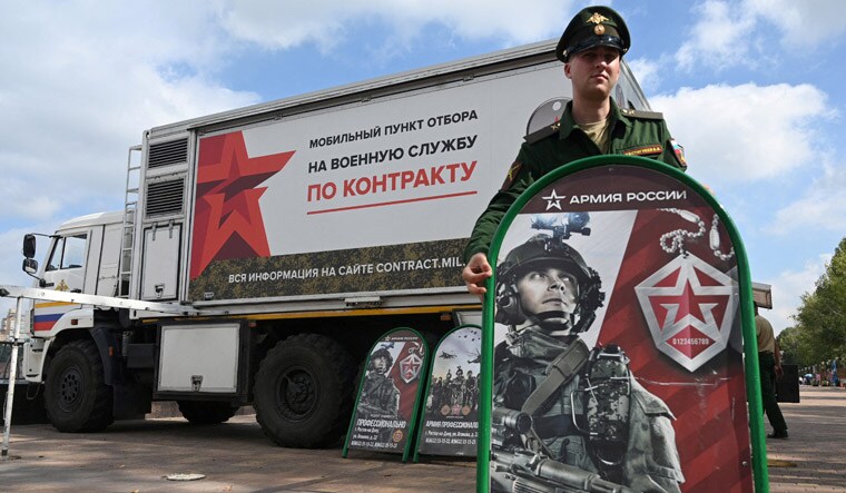 FILE PHOTO: A Russian service member stands next to a mobile recruitment center for military service under contract in Rostov-on-Don, Russia September 17, 2022. REUTERS/Sergey Pivovarov/File Photo