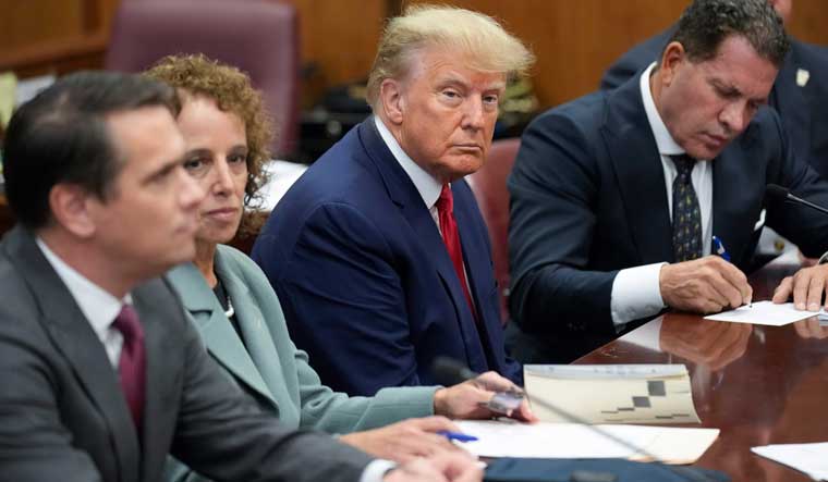 Former President Donald Trump sits at the defense table with his defense team in a Manhattan court | AP