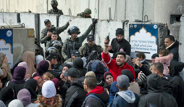 Palestinians gather in front of a security checkpoint that is designated for humanitarian special needs to be allowed to cross from the West Bank into Jerusalem, for the second Friday's Ramadan prayers at the Al Aqsa mosque compound, at the Qalandia Israeli army checkpoint, near Ramallah, Friday, March 31, 2023 | AP