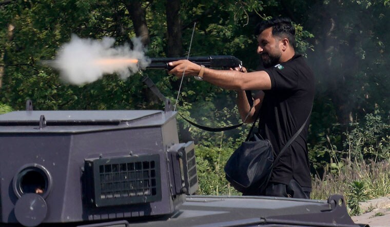 A police officer fires a repeater rifle during clashes with supporters of Pakistan's former PM Imran Khan, in Islamabad, Pakistan | Reuters