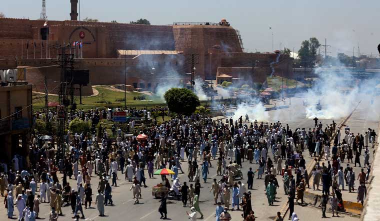 Supporters of Pakistan's former Prime Minister Imran Khan block a road as they protest against the arrest of their leader, in Peshawar | AP
