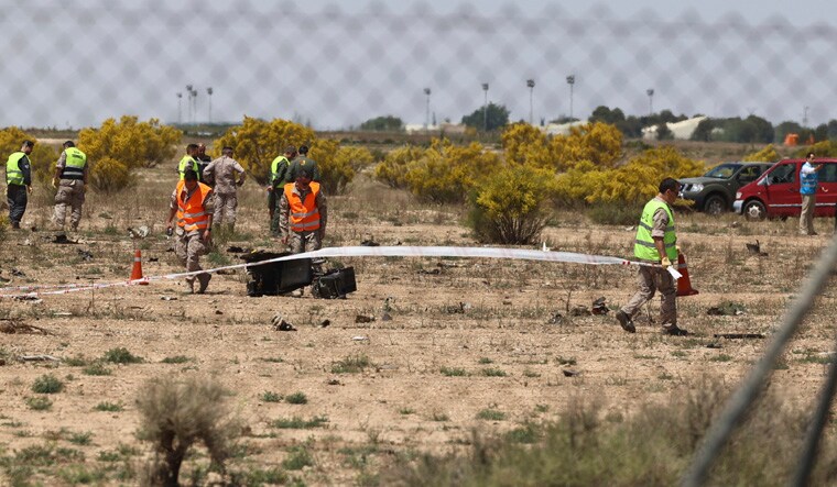 Emergency service members work in the area where an F-18 fighter jet crashed in Zaragoza, Spain, Saturday, May 20, 2023. An F-18 fighter jet crashed at an airbase in the Spanish city of Zaragoza but the pilot ejected successfully, the Spanish defense ministry said Saturday. The aircraft landed within the perimeter of the base, the defense ministry said on Twitter. (Fabian Simon/Europa Press via AP)