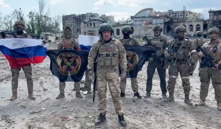 This video grab taken from a handout footage posted on May 20, 2023 on the Telegram account of the press service of Concord -- a company linked to the chief of Russian mercenary group Wagner, Yevgeny Prigozhin -- shows Yevgeny Prigozhin holding a Russian national flag in front of his soldiers holding Wagner Group's flags in Bakhmut, amid the Russian invasion of Ukraine. 
