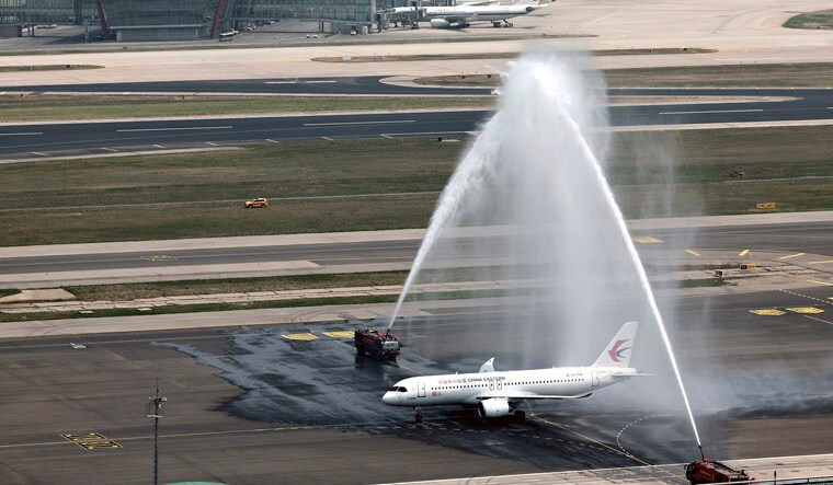 In this photo released by Xinhua News Agency, a C919 plane, China's first domestically made passenger jet is welcomed with water jets after completing its maiden commercial flight operated by China Eastern Airlines at the Beijing Capital International Airport in Beijing on Sunday, May 28, 2023. China's first domestically made passenger jet flew its maiden commercial flight on Sunday, as China looks to compete with industry giants such as Boeing and Airbus in the global aircraft market.(Wei Meng/Xinhua via AP)