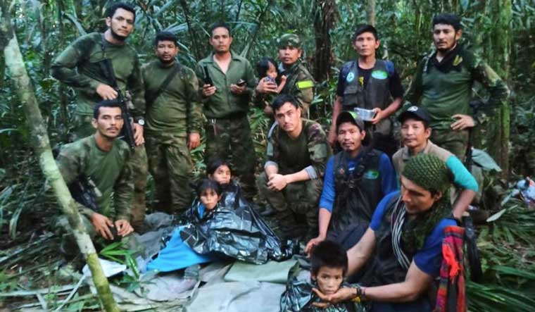 Soldiers and Indigenous men pose for a photo with the four Indigenous children who were missing after a deadly plane crash, in the Solano jungle, Caqueta state, Colombia | AP