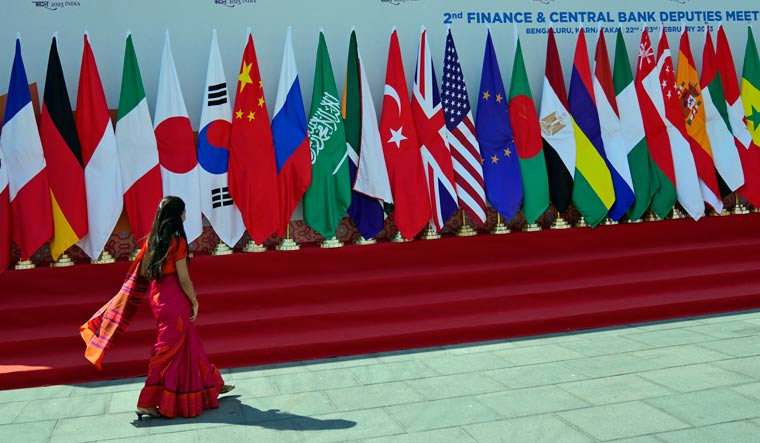 A delegate walks past a display of flags of participating countries at the venue of G-20 financial conclave on the outskirts of Bengaluru, India, Wednesday, Feb. 22, 2023 | AP