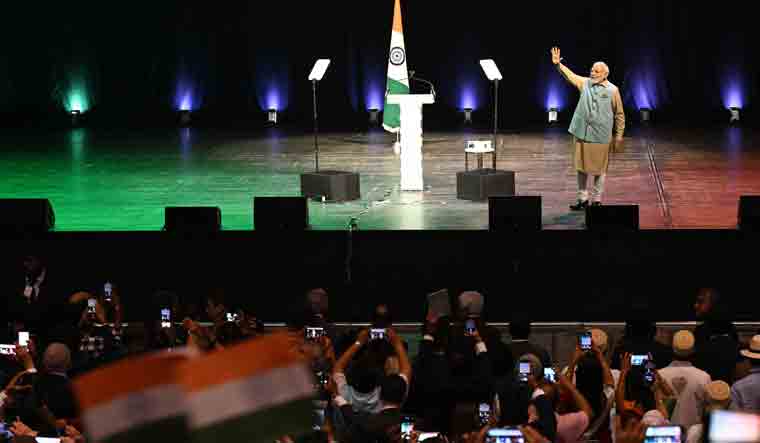 Prime Minister Narendra Modi waves on stage as he delivers a speech at the Seine Musicale, in Paris | AFP