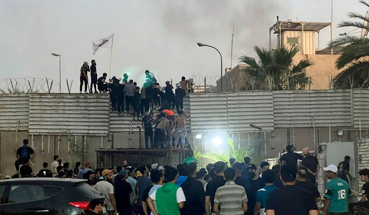 Protesters scale a wall at the Swedish Embassy in Baghdad Thursday, July 20, 2023 | AP