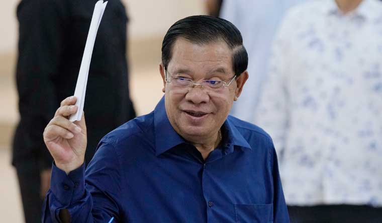Cambodian Prime Minister Hun Sen of the Cambodian People's Party raises a ballot before voting at a polling station in Southeast Phnom Penh, Cambodia | AP