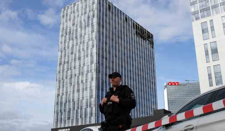 A police officer stands guard in front of a damaged business centre on Likhacheva Street after a reported drone attack in Moscow | AFP