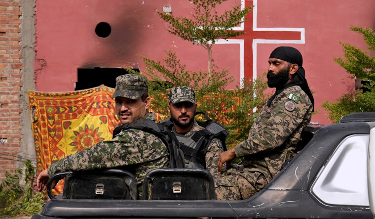 Paramilitary troops patrol after an angry Muslim mob attacked a Christian area in Jaranwala in the Faisalabad district, Pakistan, Thursday, Aug. 17, 2023. Police arrested more than 100 Muslims in overnight raids from an area in eastern Pakistan where a Muslim mob angered over the alleged desecration of the Quran by a Christian man attacked churches and homes of minority Christians, prompting authorities to summon troops to restore order, officials said Thursday. (AP/PTI)(AP08_17_2023_000021A)