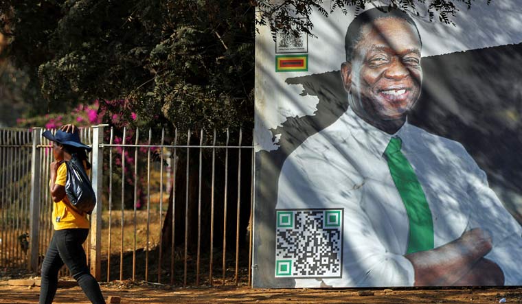A woman walks past a billboard with a face of Zimbabwe President Emmerson Mnangagwa, ahead of the presidential elections in the capital Harare, in Zimbabwe, August 22, 2023 | Reuters
